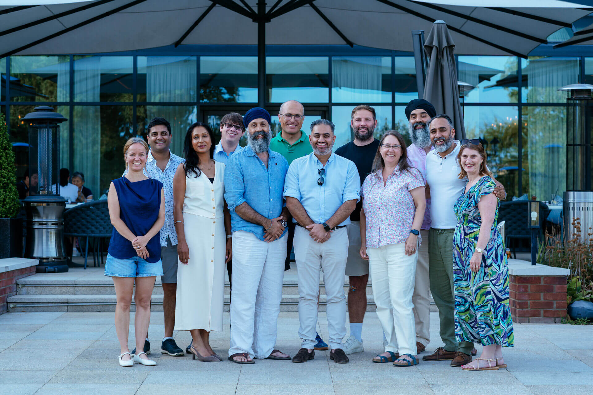 Eleven attendees pose for a group photograph on an outdoor terrace